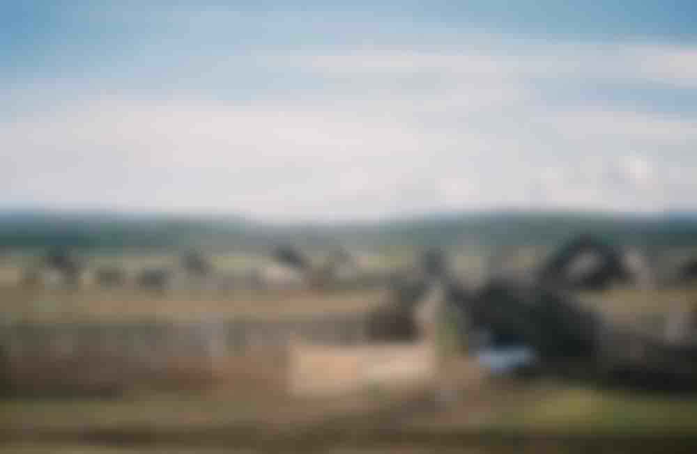 'Worn mountains' and wooden houses, location unknown.